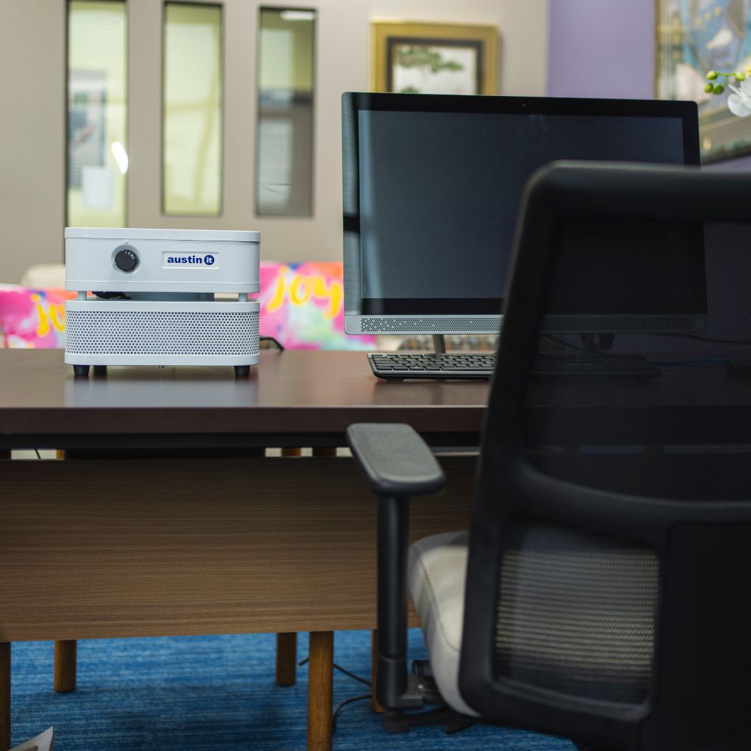 Austin Air it Personal air purifier, on an office desk